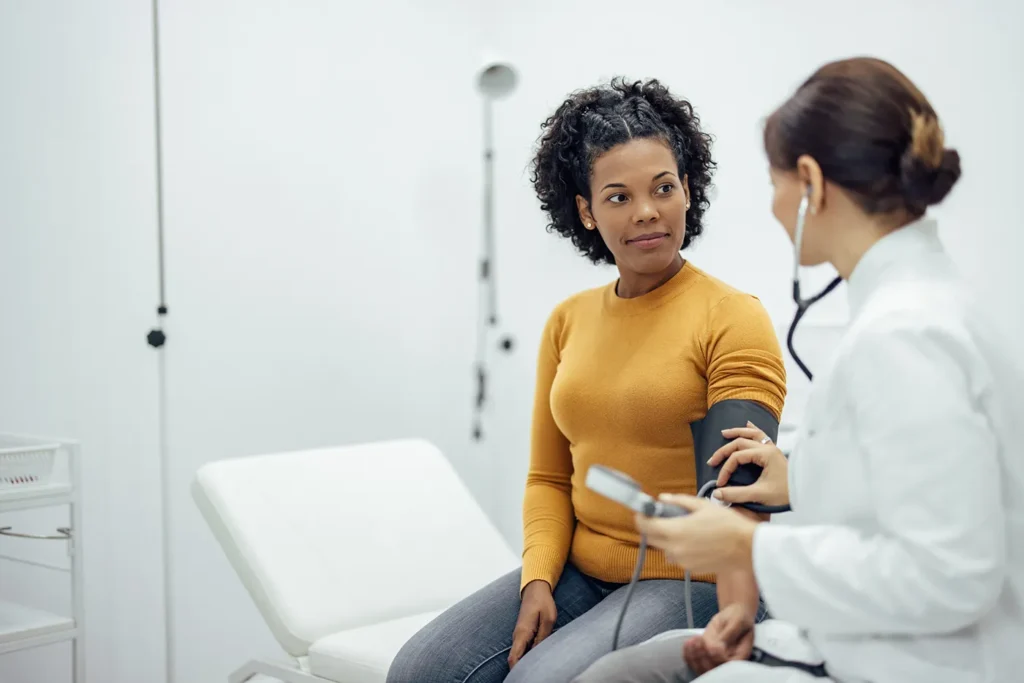 Preventive Care doctor using a stethoscope to listen to a patient’s heart during a routine checkup at Healthonomic Primary Care