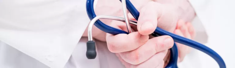 Close-up of a Healthonomic healthcare provider holding a stethoscope, ready for a patient examination.