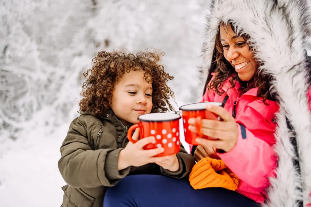 Mother and daughter drinking warm tea during winter time